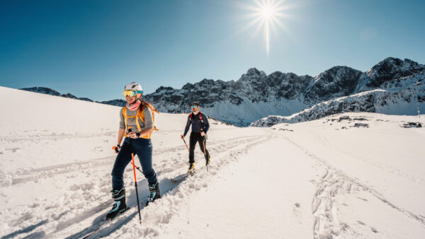 Mountaineer backcountry ski walking ski alpinist in the mountains. Ski touring in alpine landscape with snowy trees. Adventure winter sport. High tatras, slovakia landscape