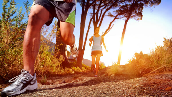 Trail running marathon athlete outdoors sunrise couple training for fitness and healthy lifestyle