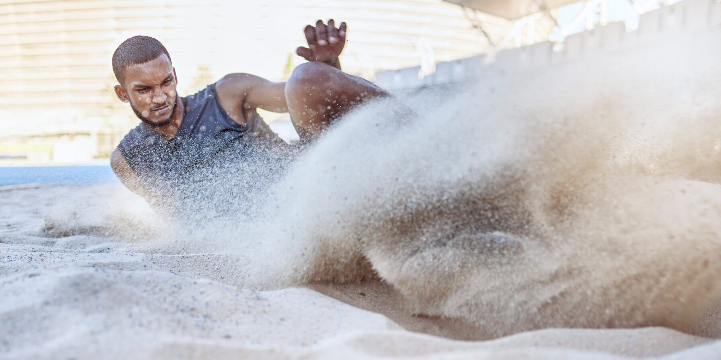 Man, athlete and sand for long jump, sport and training for sports, field and global competition. Sport, motivation and goal for podium, winning and world record for jumping at arena, stadium or park.